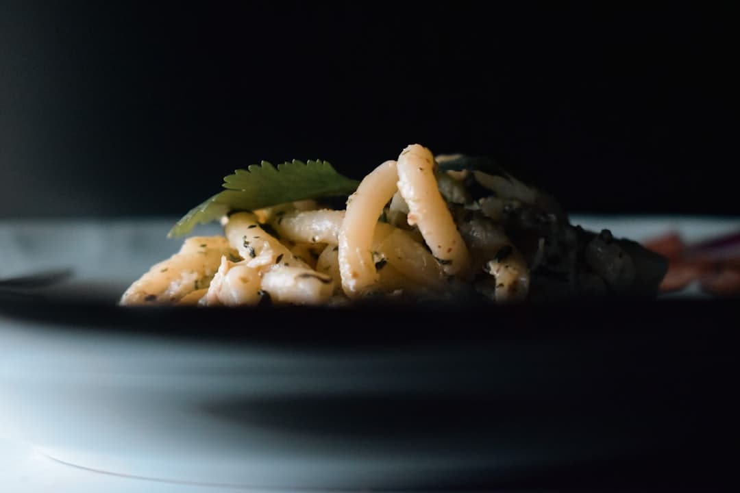 a white plate topped with pasta covered in sauce
